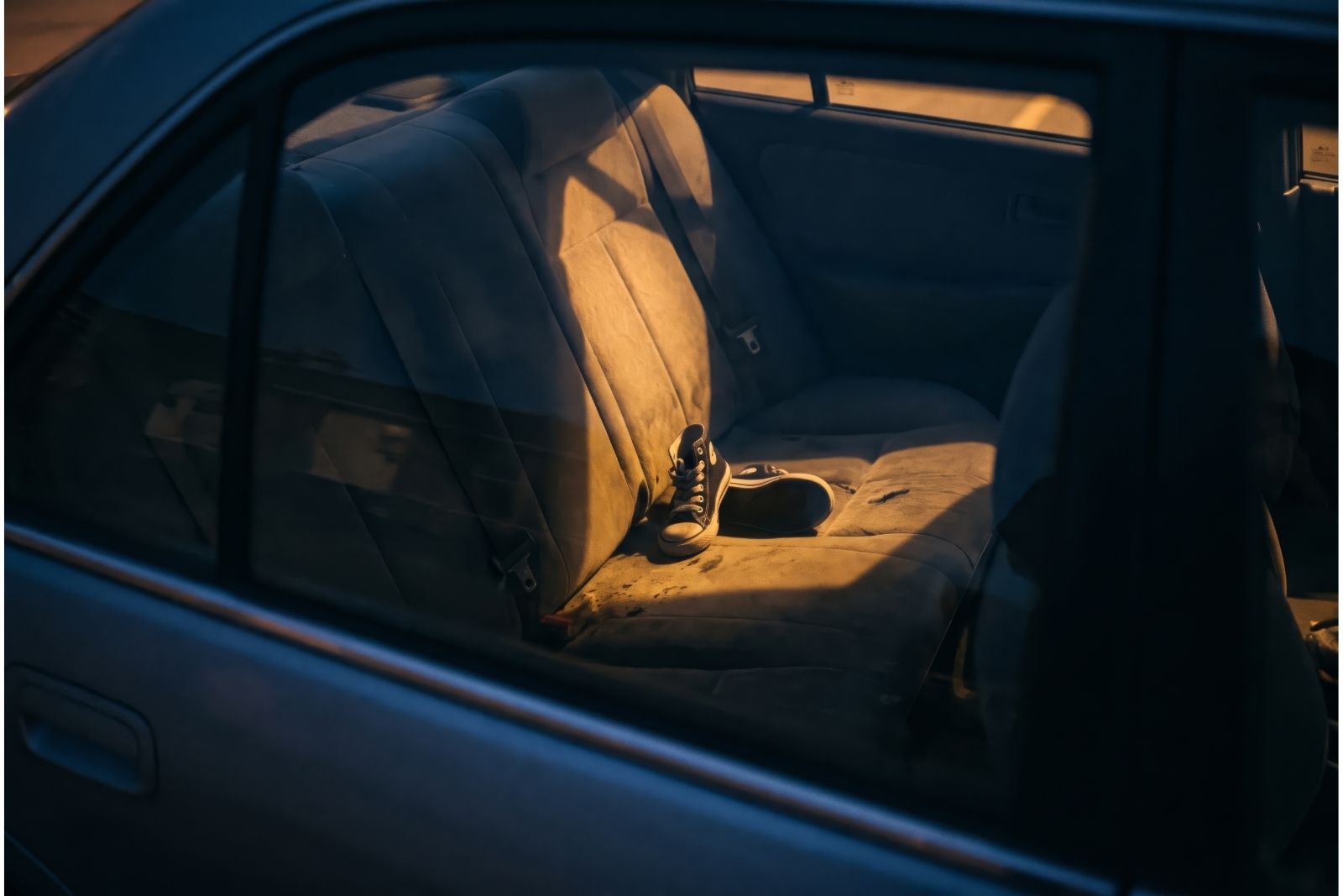 A pair of child's shoes on a car seat at night